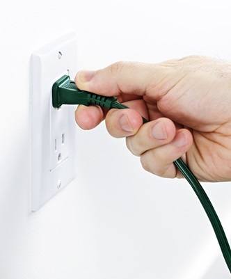 Hand removing plug from outlet