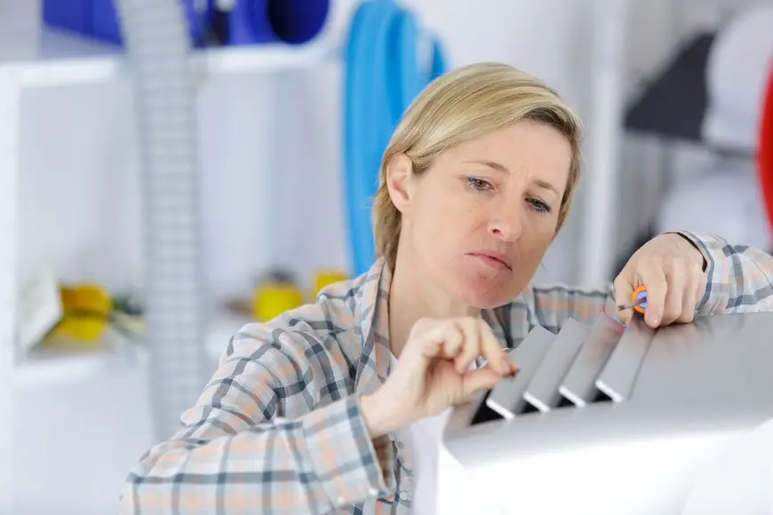 blonde handywoman cleaning fixing ventilation system