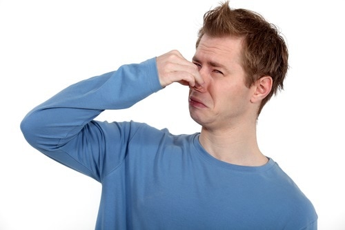 Man holding his nose against a bad smell