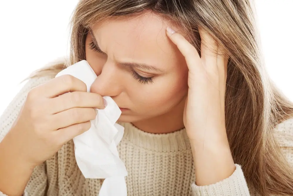 Young woman with tissues crying/ having runny nose.
