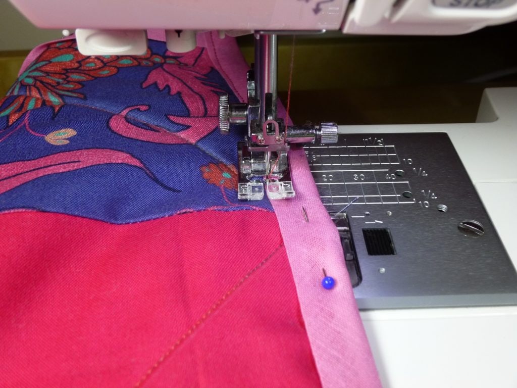 Sewing a pink cloth with pins on the side