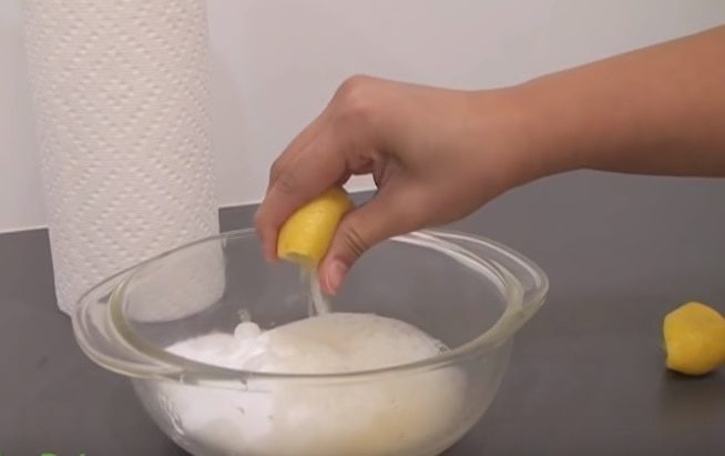 Squeezing lemon to clear bowl with baking soda and vinegar