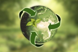 Earth with recycling arrows symbol in green background