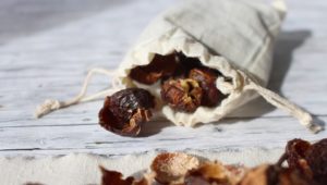 Soap nuts in cloth bag in wooden background